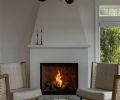 The day room flaunts a cozy fireplace with a custom plaster surround. A distinctive chandelier from Visual Comfort and shifted room orientation allow the homeowners to to fully enjoy the space The day room flaunts a cozy fireplace with a custom plaster surround. A distinctive chandelier from Visual Comfort and shifted room orientation allow the homeowners to to fully enjoy the space
