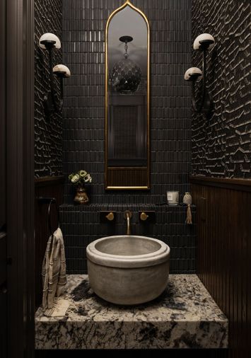 The powder room offers intensity and drama, with its textured wallpaper from Jennifer West Showroom and unique sconces from Visual Comfort The powder room offers intensity and drama, with its textured wallpaper from Jennifer West Showroom and unique sconces from Visual Comfort
