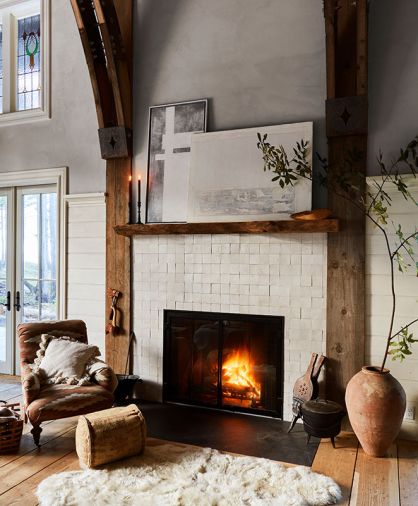 Guests can cozy up on a Manor Fine Wares armchair alongside the glistening Zellige Ann Sacks tiled fireplace, its mantel and surround crafted from wood felled on the property. Guests can cozy up on a Manor Fine Wares armchair alongside the glistening Zellige Ann Sacks tiled fireplace, its mantel and surround crafted from wood felled on the property.