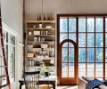 Casual living is enhanced by the rough-sawn 12  plank flooring, this corner is a perfect spot for game night and puzzles. The wooden picture window with an integrated arched doorway shows Arciform’s precision and detail found throughout the home. The white oak and steel shelving offers a place for keepsakes and books while a vintage orchard ladder gives access to high shelves. Casual living is enhanced by the rough-sawn 12  plank flooring, this corner is a perfect spot for game night and puzzles. The wooden picture window with an integrated arched doorway shows Arciform’s precision and detail found throughout the home. The white oak and steel shelving offers a place for keepsakes and books while a vintage orchard ladder gives access to high shelves.
