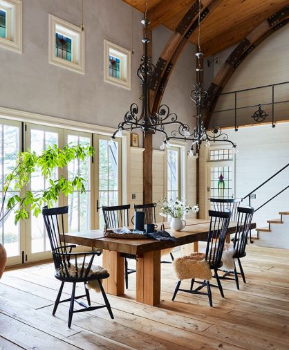 Antique church chandeliers were salvaged to light Richard’s massive table and sheepskins soften the dining room chairs. Arciform crafted the transom window that sits atop the stained-glass door, matching the door height. Antique church chandeliers were salvaged to light Richard’s massive table and sheepskins soften the dining room chairs. Arciform crafted the transom window that sits atop the stained-glass door, matching the door height.