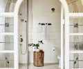 Anne wisely showcased the stunning salvaged stained-glass door discovered at Bloomsbury Art & Fine Antiques for the primary bath’s entry. “Milk Mustache” paint by Dunn Edwards echoes the door’s trim, while Ann Sacks Carrara hex tile grounds the room. Anne wisely showcased the stunning salvaged stained-glass door discovered at Bloomsbury Art & Fine Antiques for the primary bath’s entry. “Milk Mustache” paint by Dunn Edwards echoes the door’s trim, while Ann Sacks Carrara hex tile grounds the room.