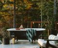 A salvaged clawfoot tub perches upon the wraparound galvanized perforated metal decking, assuring privacy thanks to the well-forested 12-acre plot of land. A Room & Board Breeze chair awaits alongside. A salvaged clawfoot tub perches upon the wraparound galvanized perforated metal decking, assuring privacy thanks to the well-forested 12-acre plot of land. A Room & Board Breeze chair awaits alongside.