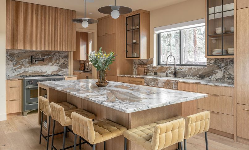 The honey-toned kitchen includes Kelly Wearstler lighting, Vittara Brown quartzite backsplash and counters, and rift white oak cabinetry. Bringing in additional warmth are CB2 barstools, and white oak flooring. The honey-toned kitchen includes Kelly Wearstler lighting, Vittara Brown quartzite backsplash and counters, and rift white oak cabinetry. Bringing in additional warmth are CB2 barstools, and white oak flooring.