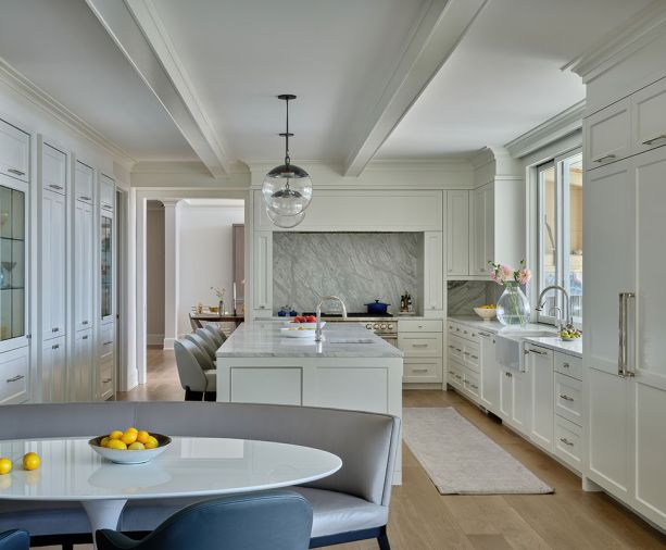 Stunning flow-matched Calacatta Gold marble counters and backsplash shine amidst the reconfigured kitchen, featuring new floor-to-ceiling cabinets (left), crown molding, and ceiling beams. Stunning flow-matched Calacatta Gold marble counters and backsplash shine amidst the reconfigured kitchen, featuring new floor-to-ceiling cabinets (left), crown molding, and ceiling beams.