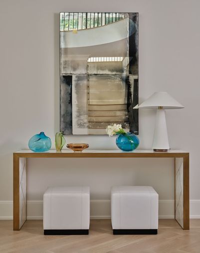 The home’s flooring was replaced with white oak flooring from Eurocraft Hardwood Floors, LLC (now Montello Design). Homeowners’ curated artwork is reflected in a mirror along with stairwell and mezzanine. The home’s flooring was replaced with white oak flooring from Eurocraft Hardwood Floors, LLC (now Montello Design). Homeowners’ curated artwork is reflected in a mirror along with stairwell and mezzanine.