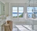 The completely redesigned primary bath glows with exquisite slabs of flow-matched Calacatta Caldia marble honed across every surface. Custom floating dual vanities by Barneswood Custom Cabinets with makeup chair offer views of Lake Washington. The completely redesigned primary bath glows with exquisite slabs of flow-matched Calacatta Caldia marble honed across every surface. Custom floating dual vanities by Barneswood Custom Cabinets with makeup chair offer views of Lake Washington.