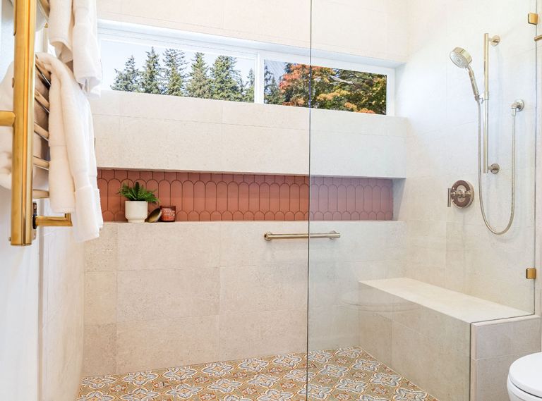 An expansive, curbless, walk-in shower now facilitates easy aging-in-place, select finishes like the Wayfair Merola Tile on the floor and Terracotta tile from CFM in the linear storage niche, both a nod to the client’s Spanish heritage. A towel warmer and shower fittings are the finishing touch. An expansive, curbless, walk-in shower now facilitates easy aging-in-place, select finishes like the Wayfair Merola Tile on the floor and Terracotta tile from CFM in the linear storage niche, both a nod to the client’s Spanish heritage. A towel warmer and shower fittings are the finishing touch.